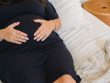 Photo by Amina Filkins; pregnant woman embracing belly